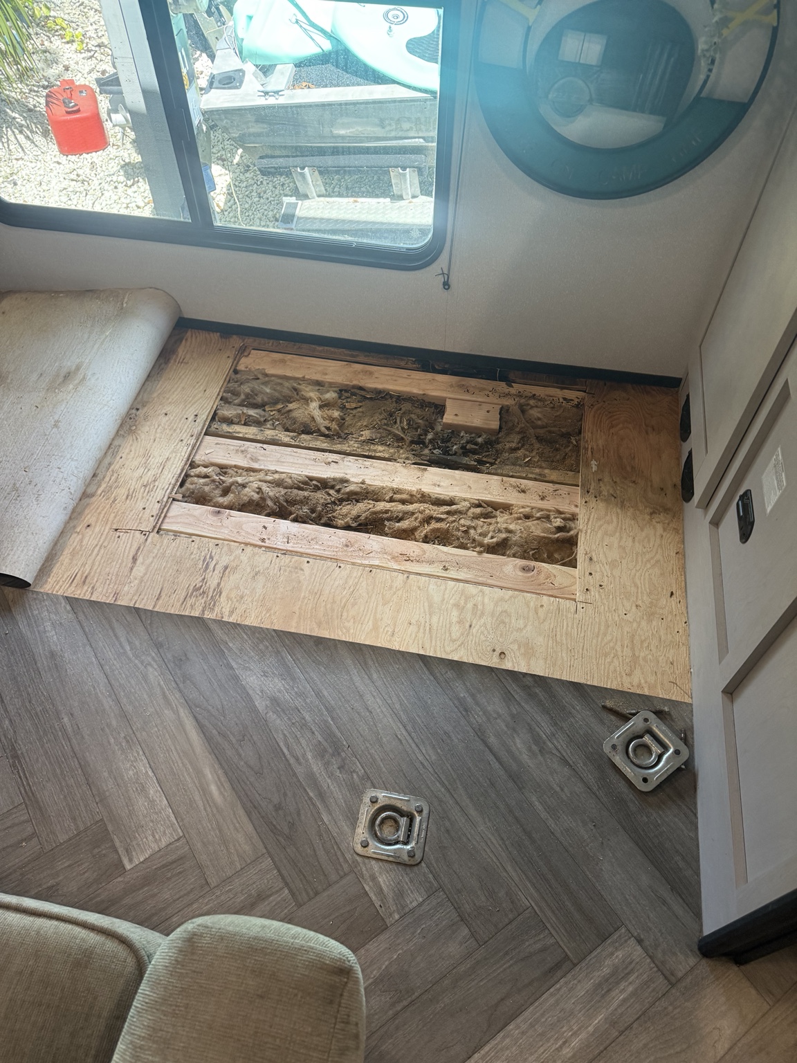 Window-side floor opened, with the existing linoleum rolled back.