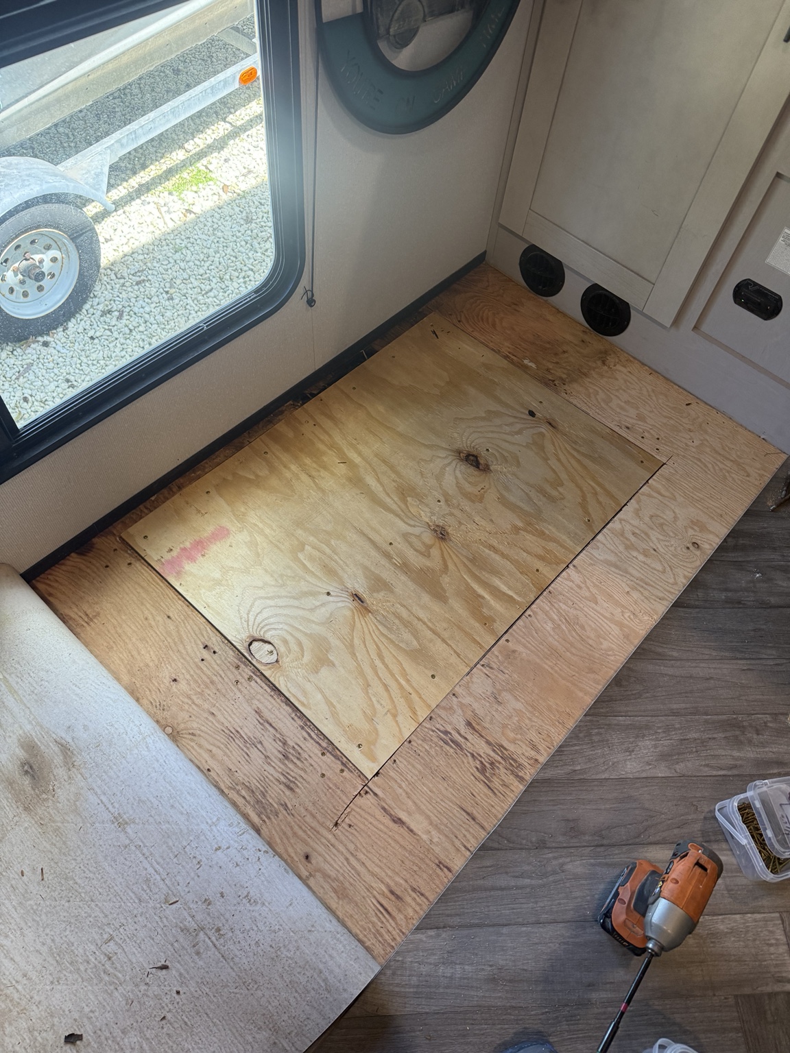 Window-side plywood patch installed before the linoleum was returned.