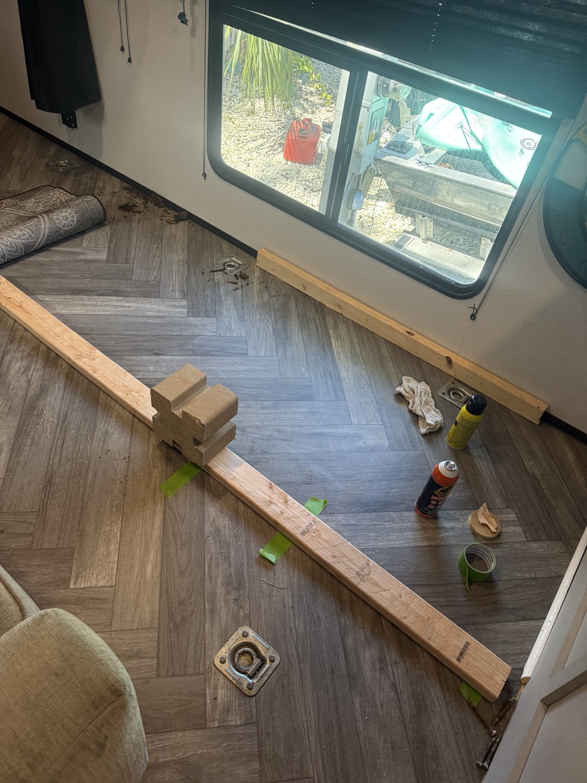 Existing linoleum laid back over the repaired area, with tools and temporary weights still present.